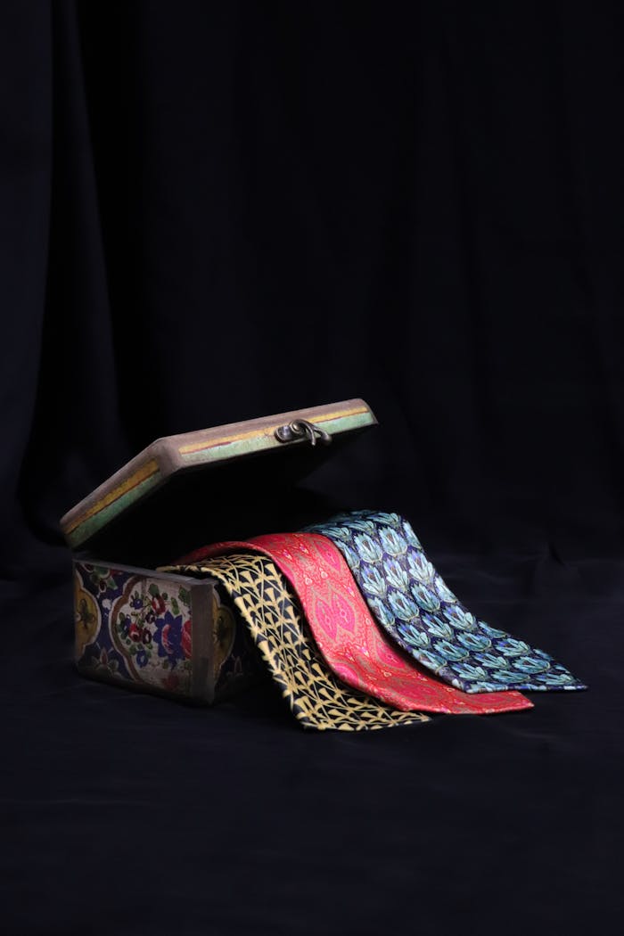 A collection of colorful silk ties displayed in an ornate vintage box, perfect for men's fashion and accessories needs.
